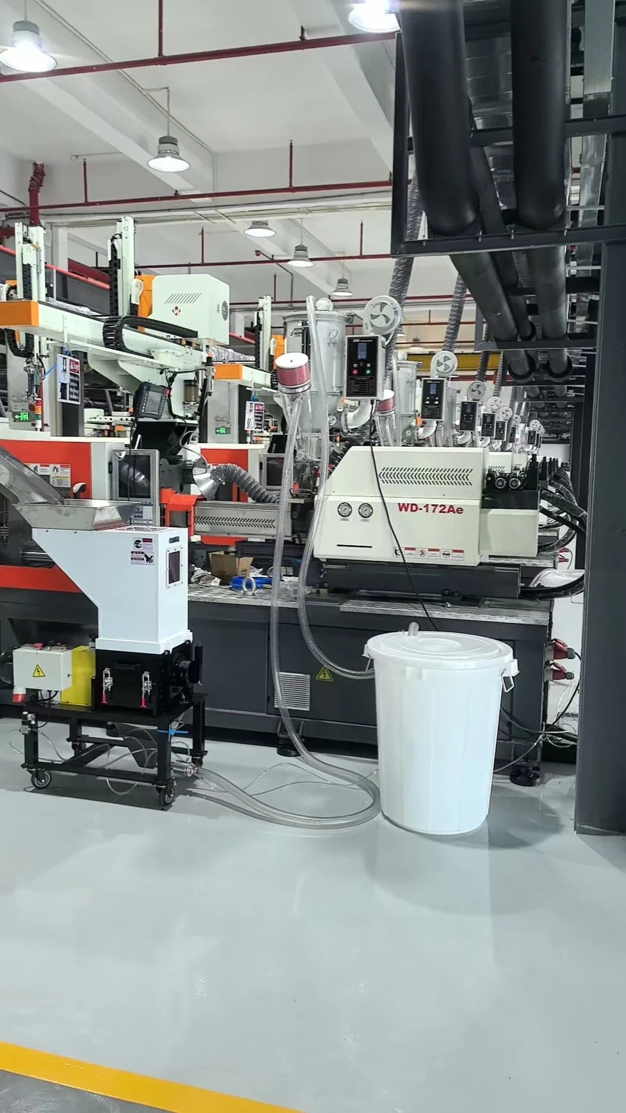 HGS slow-speed granulator beside injection molding equipment, with dryers and further molding machines visible behind it.