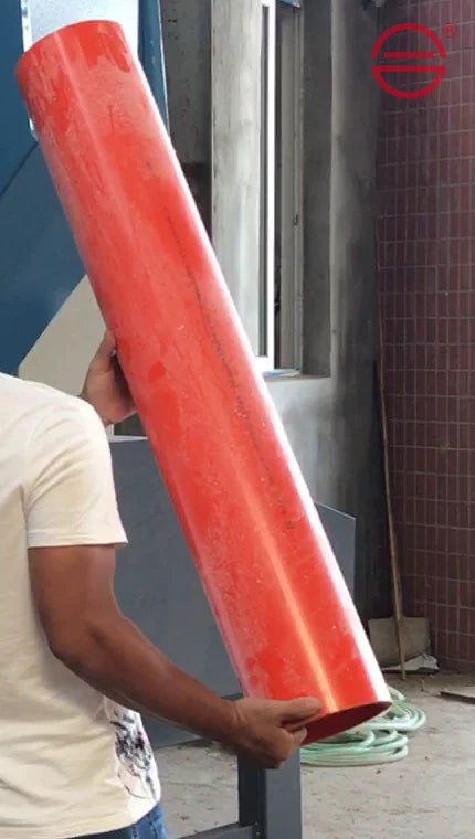 A long red plastic pipe held beside the pipe granulator.